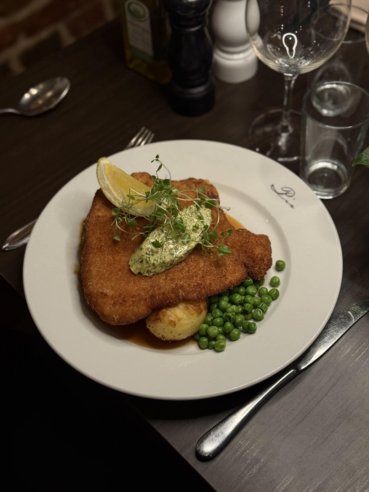 Pios schnitzel med örtsmör, skysås, ärtor och potatis